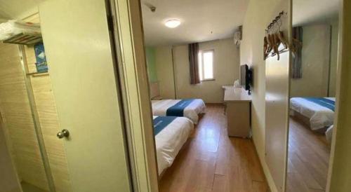 a hotel room with two beds and a hallway at 7 Days Inn Xi'an North Economic Development Zone 4th Fengcheng Road in Xi'an