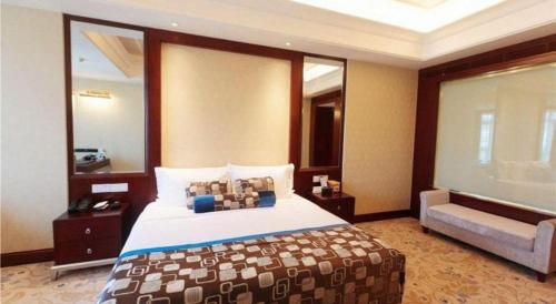 a bedroom with a large bed and a couch at Linyi Blue Horizon International Hotel Yi He in Linyi