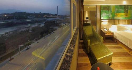 a bedroom with a large window with a view of a highway at GreenTree Inn Fujian Fuzhou Software Park River View Business Hotel in Fuzhou