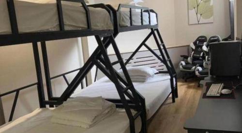 two bunk beds in a room with a desk and a computer at GreenTree Inn Xinjiang Uygur Autonomous Region Korla Bazhou Bus Terminal Beishan Road Express Hotel in Korla
