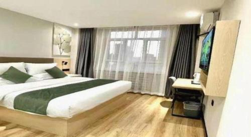 a bedroom with a bed and a desk and a window at GreenTree Inn Xinjiang Uygur Autonomous Region Korla Bazhou Bus Terminal Beishan Road Express Hotel in Korla