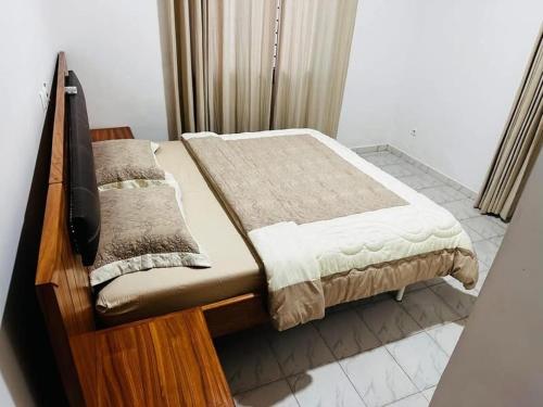 a bedroom with a bed with a wooden frame at Villa Witroos luxury and elegance in Yaoundé