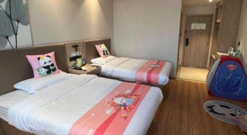 a hotel room with two beds and a suitcase at GreenTree Inn Xuzhou High Speed Railway Station Express Hotel in Xuzhou