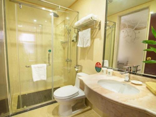 GreenTree Inn Jiangsu Wuxi Xishan DongTing Erquan East Road XinGuang Newly Estate Express Hotel في ووشي: حمام مع دش ومرحاض ومغسلة