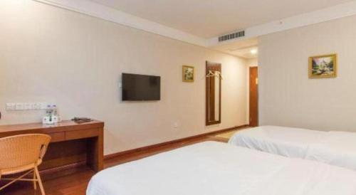 a hotel room with two beds and a desk and a television at GreenTree Inn Hefei Huangshan Road Daxidi 1912 Express Hotel in Hefei