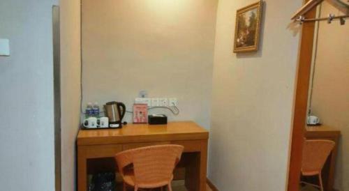 a room with a wooden table with two chairs at GreenTree Inn Hefei Huangshan Road Daxidi 1912 Express Hotel in Hefei