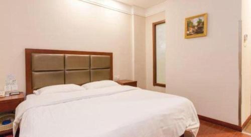 a bedroom with a large white bed in a room at GreenTree Inn Hefei Huangshan Road Daxidi 1912 Express Hotel in Hefei