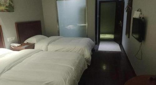 a hotel room with two beds and a television at GreenTree Inn Yancheng Vehicle Administrative office Test Center Express Hotel in Yancheng