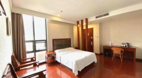 a hotel room with a bed and a desk and a bed sidx sidx sidx at GreenTree Inn Hefei Huangshan Road Daxidi 1912 Express Hotel in Hefei