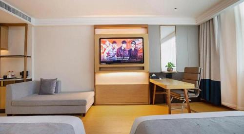 a hotel room with a television on the wall at GreenTree Inn Taiyuan PinGYAng Road Business Hotel in Taiyuan