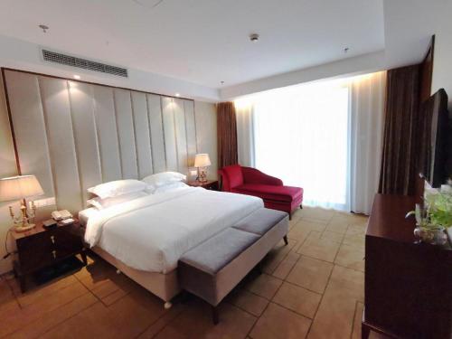 a bedroom with a large bed and a red chair at Jinjiang Metropolo Shanghai Minhang in Shanghai