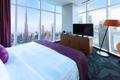 a hotel room with a large bed and a television at Park Regis Business Bay in Dubai