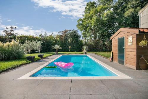 a swimming pool with a float in a backyard at Bed and Breakfast Goeree Overflakkee in Sommelsdijk