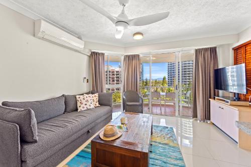 a living room with a couch and a tv at Surf Parade Resort in Gold Coast
