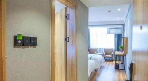 a bedroom with a bed and a living room at GreenTree Inn Hefei Chenghuangmiao San Xiao Kou Subway Station Hotel in Hefei