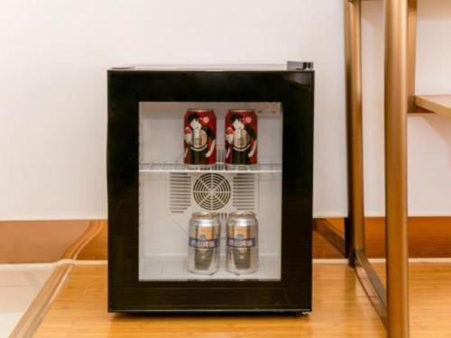 a picture of a refrigerator with drinks in it at GreenTree Inn Qufu High Speed Railway Station in Jining