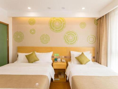 a hotel room with two beds and a window at GreenTree Inn Qufu High Speed Railway Station in Jining
