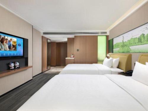a hotel room with two beds and a flat screen tv at Hampton by Hilton Zhuhai Doumen in Zhuhai