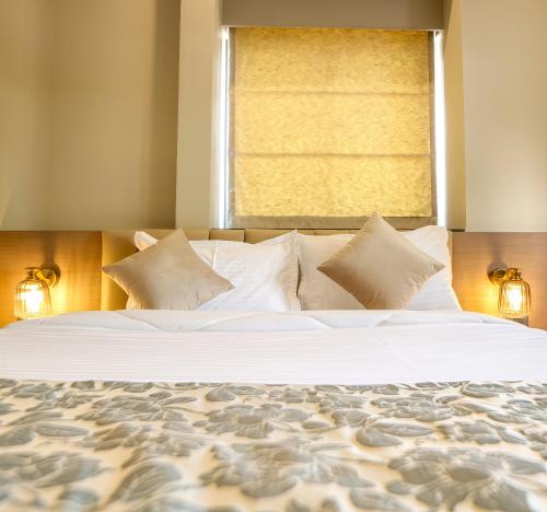 a bedroom with a large bed with a window at The Falcon Inn in Mumbai