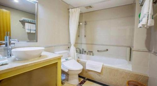 a bathroom with a sink and a toilet and a tub at Zhongshan Louis Hotel in Zhongshan