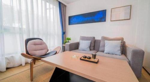 a living room with a table and a couch at Zhongshan Louis Hotel in Zhongshan