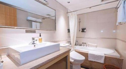 a bathroom with a sink and a tub and a toilet at Zhongshan Louis Hotel in Zhongshan