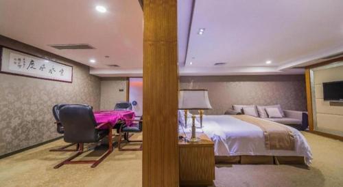 a hotel room with a bed and a desk and a bed sidx sidx sidx sidx at Zhongshan Louis Hotel in Zhongshan
