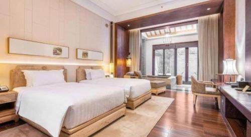 a bedroom with a large white bed and a desk at Xian Huaqingyutang Hotel in Xi'an