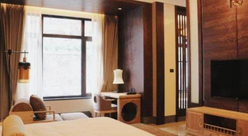 a hotel room with a bed and a television at Xian Huaqingyutang Hotel in Xi'an