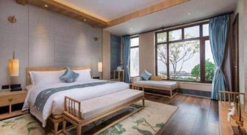 a bedroom with a large bed and a large window at Xian Huaqingyutang Hotel in Xi'an