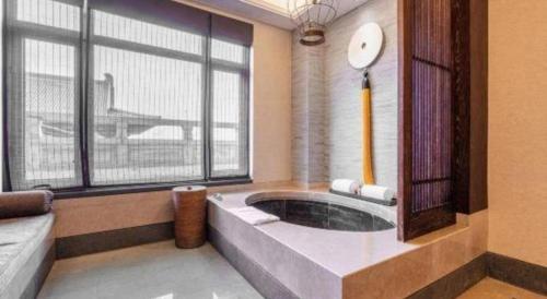 a large bathroom with a tub with a large window at Xian Huaqingyutang Hotel in Xi'an