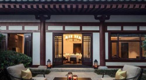 a patio with chairs and a table in front of a building at Xian Huaqingyutang Hotel in Xi'an