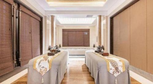 a room with a row of beds with a tub at Xian Huaqingyutang Hotel in Xi'an