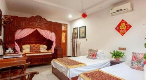 a room with two beds and a desk in a room at Pingyao Yufengheng Hotel in Pingyao