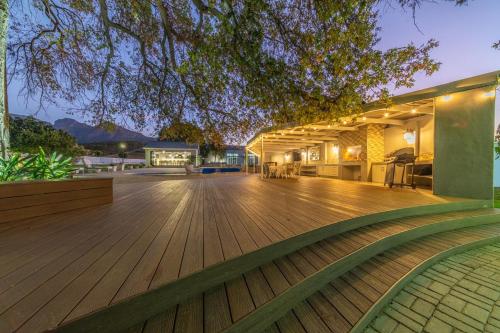 an outdoor deck with a wooden floor and a building at Room 1 - LEO Sky Guest House in Simondium