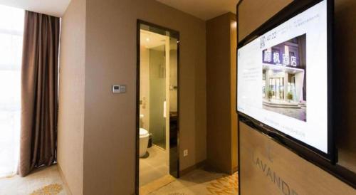 a room with a television and a bathroom with a toilet at Lavande Hotel Guangzhou Tianhe Park Metro Station in Guangzhou