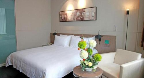 a hotel room with a bed and a table with flowers at Jinjiang Inn Xi'an Zhonglou North Street Metro Station in Xi'an