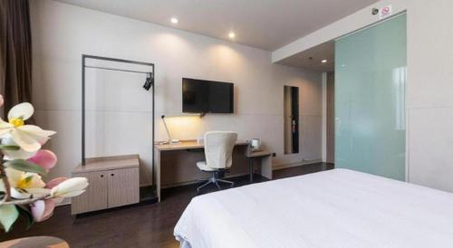 a bedroom with a bed and a desk with a computer at Jinjiang Inn Xi'an Zhonglou North Street Metro Station in Xi'an