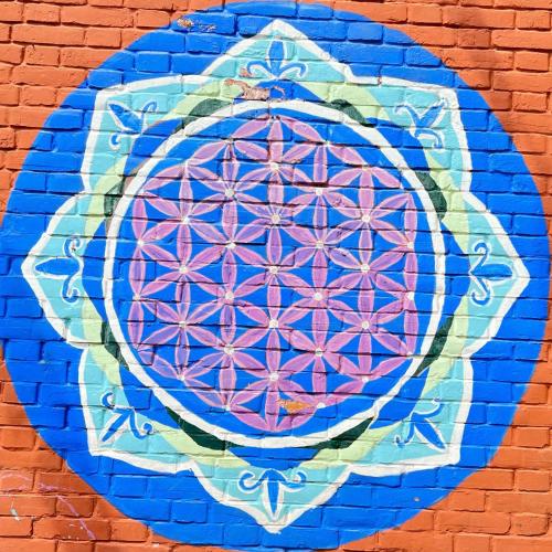 a wall with a painting of a flower on it at Joy Source Resort in Kathmandu