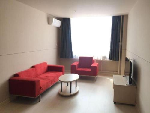 a living room with a red couch and two chairs at Jinjiang Inn Handan Zhonghua Nan Street Xueyuan Bei Road in Handan