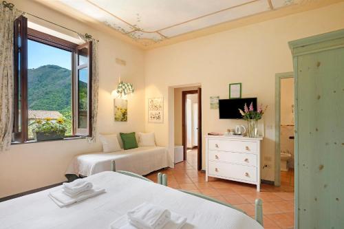 a hotel room with two beds and a window at Agriturismo Barone Antonio Negri in Fisciano