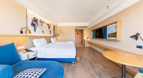a hotel room with a large bed and a table at Kyriad Marvelous Hotel·Xi'an North High-speed Railway Station in Xi'an