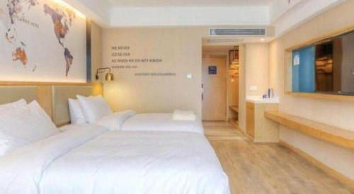 a hotel room with a large white bed and a tv at Kyriad Marvelous Hotel·Xi'an North High-speed Railway Station in Xi'an