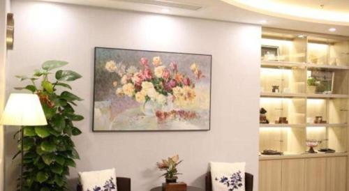 a painting of a vase of flowers on a wall at Cozy Hotel Xiamen in Xiamen