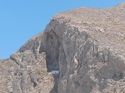 a small white house on the side of a mountain at Ancient Thera Apartments in Kamari