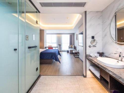 a hotel room with a bed and a bathroom at Yitel Collection Lianyungang High-speed Railway Station Suning Plaza in Lianyungang