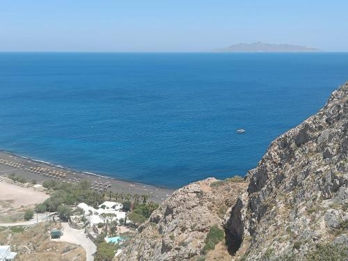 a view of a beach from a mountain with the ocean at Ancient Thera Apartments in Kamari