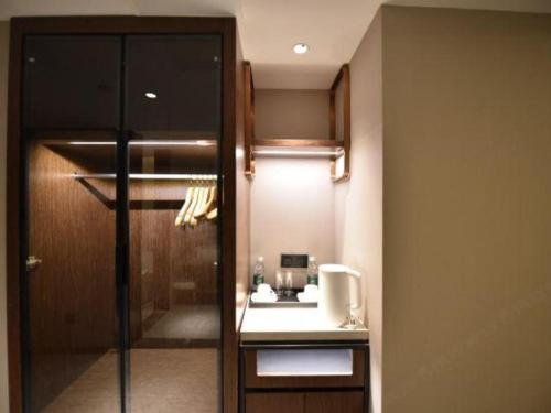 a bathroom with a sink and a glass door at Yitel Collection Lianyungang High-speed Railway Station Suning Plaza in Lianyungang