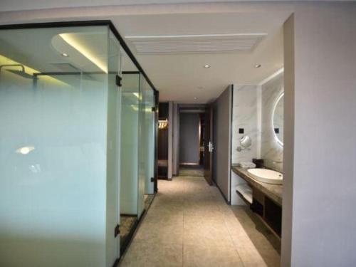 a bathroom with a sink and a mirror at Yitel Collection Lianyungang High-speed Railway Station Suning Plaza in Lianyungang