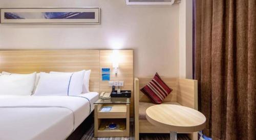a hotel room with a bed and a table at City Comfort Inn Beihai RT-Mart High Speed Railway Station in Beihai